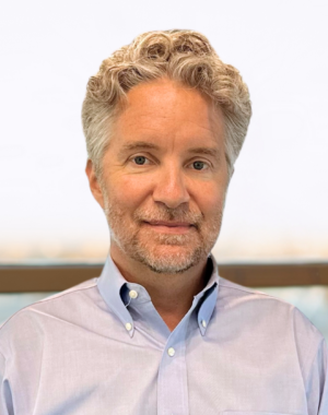 a man with grey hair and beard wearing a blue shirt