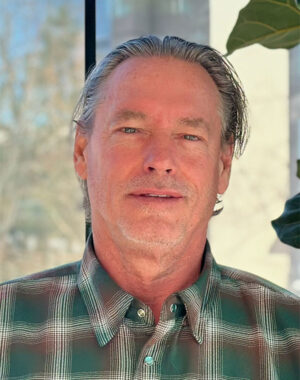 a man with grey hair and a plaid shirt