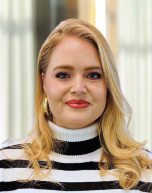 a woman with blonde hair wearing a black and white striped shirt