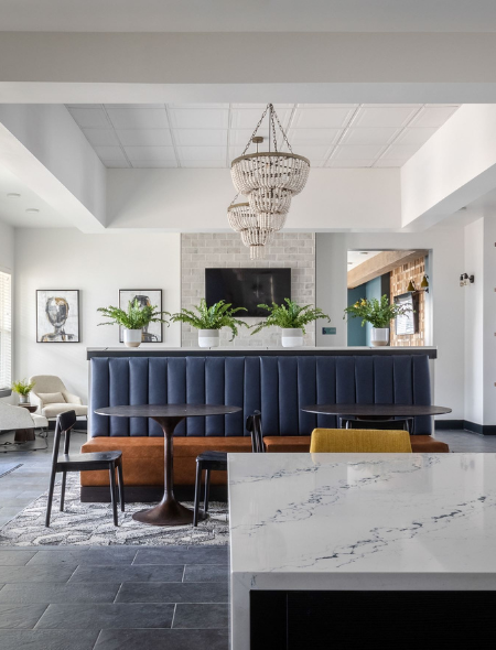 a room with a blue booth and a white marble counter